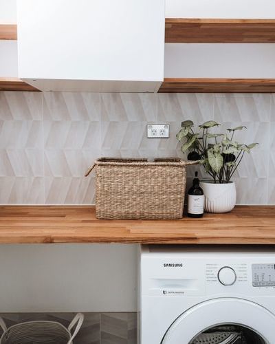 Auf dem Bild sind Holzregale mit einem Korb und einem Blumentopf zu sehen&period; Unter dem unteren Holzregal steht eine Waschmaschine und links daneben ein W&auml;schekorb&period; pexels-rachel-claire-4993073